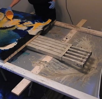 a person is painting a large painting on a table