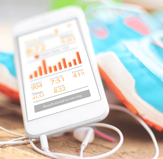 a cell phone in front of a pair of running shoes