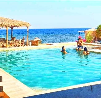 Pessoas na piscina com vista para o mar na estrela beduína Ras shitan Nuweiba Egito