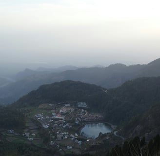 a view of a mountain range with a lake and a small town