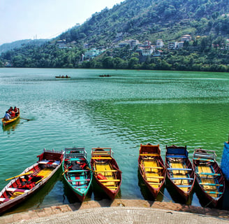 a group of people in a row boat on a lake