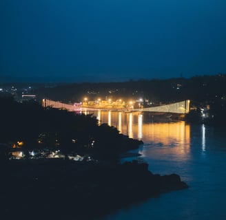 a bridge spanning a river with a bridge in the background