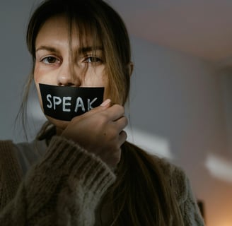 Woman with black eye with speak wrote on tape on her mouth