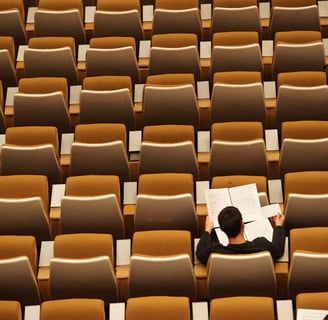 a man sitting in a chair in a room with many chairs