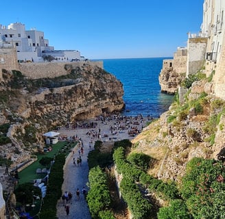 "Polignano a Mare, Italy—coastal town with dramatic limestone cliffs, crystal-clear Adriatic waters,