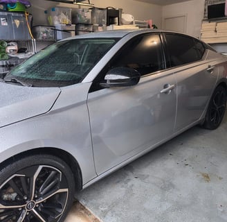 a car parked in a garage with a car in the background
