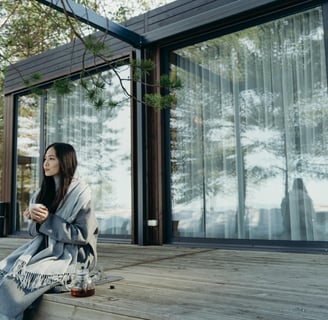 a woman sitting on a deck with a coffee cup