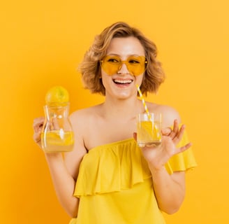 a woman in a yellow dress holding glasses of lemonade