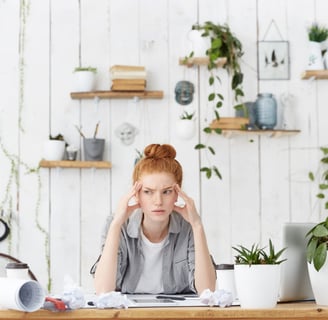 a woman sitting at a desk with a tablet