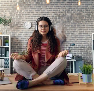 a woman sitting on a desk with headphones on