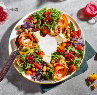 a plate of food with a wreath of vegetables and fruit
