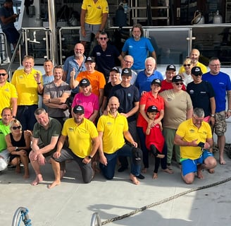 a group of people standing on a diving safari boat