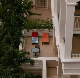a balcony with a table and chairs in the middle of the room