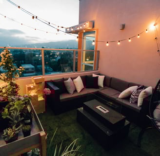 a couch with pillows and a table with a table with a plant