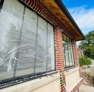 Technicien professionnel nettoyant des vitres à Lisieux avec des équipements modernes