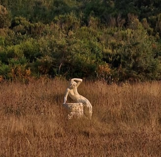 a statue of a man sitting on a rock