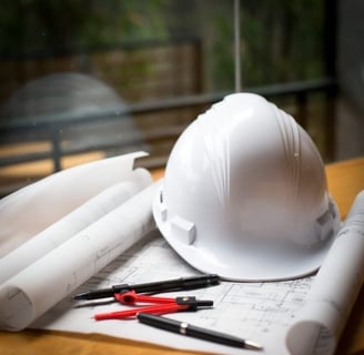 Construction hardhat and building drawings