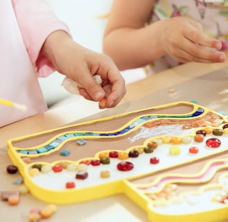 a child's hands are holding a beaded necklace
