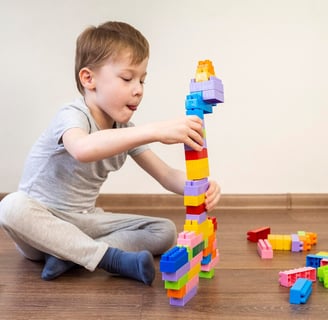 a young boy playing with blocks on the floor