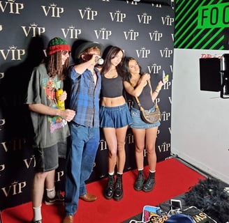 4 people posing in front of a VIP backdrop in a digital photo booth in Brisbane.
