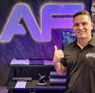 Kahn from SweetAz Co. in front of the Anytime Fitness sign at the Chermside gym during their grand opening event.