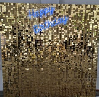 Gold shimmer wall set up at Tipene's daughters 10th birthday with a blue Happy Birthday neon in Logan