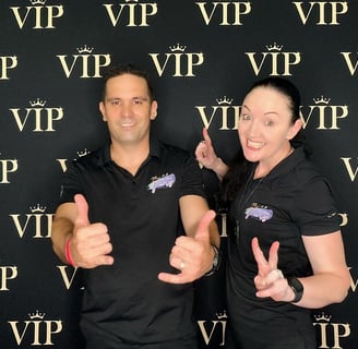 Carly and Kahn from SweetAz Co. posing in front of the VIP backdrop in the open air digital photo booth at an event in Brisba