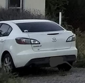 a white car parked on a gravel road