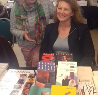 Sophie Stern écrivaine avec son éditrice dans un salon du livre, assise une table avec ses livres