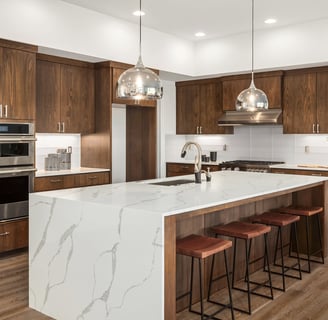 Modern kitchen renovation with marble waterfall island and wood cabinetry in London, Ontario.