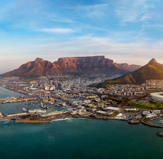 Aerial view of Cape Town with Table Mountain, city bowl, and coastline at sunrise — ideal for landscape photography.