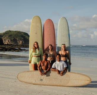 Surf school Kuta Lombok team and students posing with surfboards on the beach in Indonesia