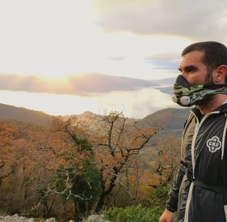 a man wearing a mask and a mask on a mountain