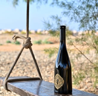 a bottle of daskali's wine on a wooden bench