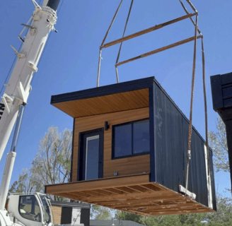 Tiny home pod lifted by crane for easy placement on site