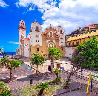 a church with a clock tower and palm trees in Candelaria