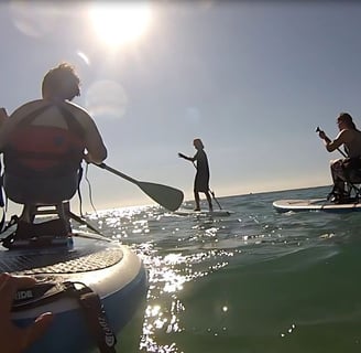 a man and woman paddle boarding in the ocean