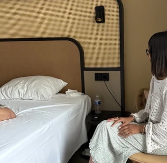 Encadrante assise à côté d'une participante allongée sur un lit lors d'une session privée 