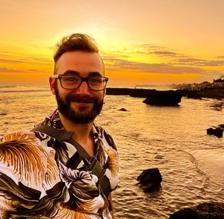 a man with a beard and glasses taking a selfie