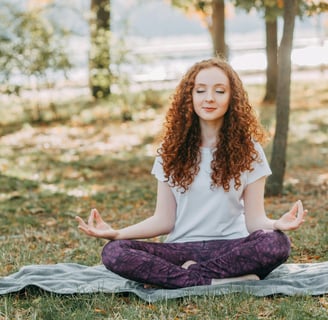 A peaceful person meditating in nature, representing the mental health benefits of meditation on Wor