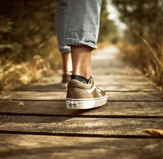 A person walking on a scenic trail, showcasing the physical benefits of walking for weight loss and 