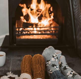 A cozy living room with a warm fireplace, thick blankets, and energy-efficient space heaters,