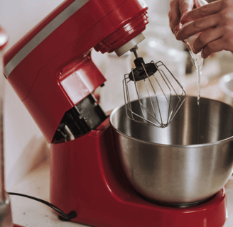 a person is holding a mixer and mixing a bowl