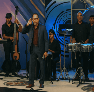 Franko Arias y su orquesta en vivo durante presentación musical con instrumentos y escenario profesi