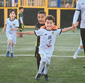 لاعبو نادي المجد الرياضي عين السبع الصغار يحتفلون بتسجيل هدف أثناء المباراة