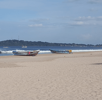 a beach with several boats and a boat in the water