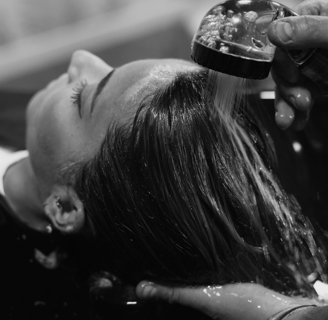 a woman is getting her hair done by a hairdresser