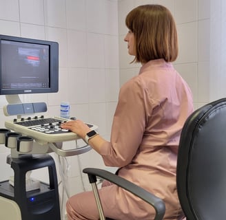 a woman in a pink shirt is sitting at a computer