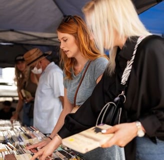 a woman looking at a book on a table