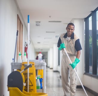 a man in a uniform cleaning a hallway